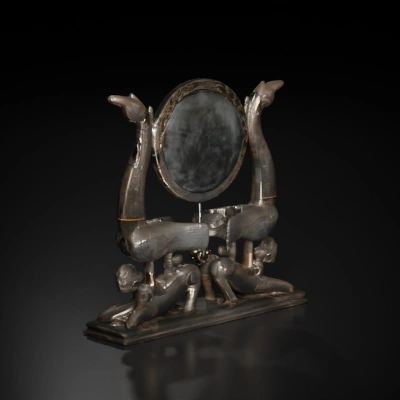 Twin mythological creatures supporting a mirror.