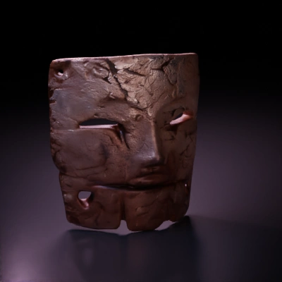 Ancient carved stone face mask, tribal or historical artifact.