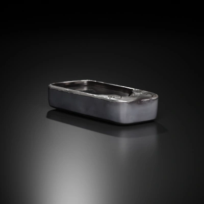 Rectangular metallic object with engraved design.