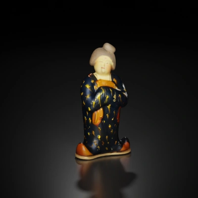 Ceramic figurine, traditional attire, holding a fish.