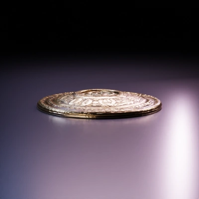 Decorative round shield, intricate patterns.