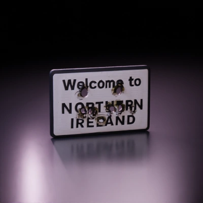 Welcome to NORTHERN IRELAND Damaged street sign with bullet holes. Old